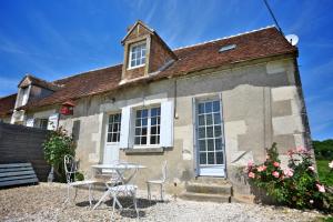 an old stone house with a table and chairs at Domaine de Matounet in Bridoré