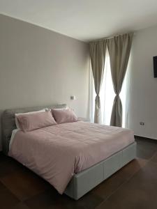 a bedroom with a bed with pink pillows and a window at Relais Petruzzelli in Bari