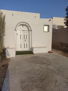 een wit gebouw met een witte deur bij S1 Beltaief Residence in Houmt Souk