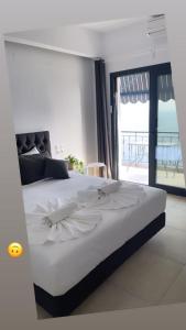 a bedroom with a large white bed with a balcony at Pargas paradise in Parga