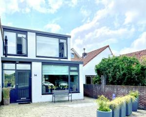 uma casa com um banco à frente em Alibi aan Zee em Wijk aan Zee