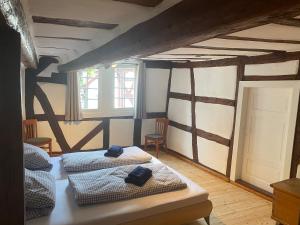 a bedroom with two beds in a room with beams at Ferienwohnung Obergasse in Zwingenberg