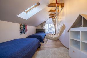 a bedroom with two beds and a hammock at Nida Urbas Hill Apartments in Nida