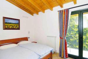 - une chambre avec un lit et une grande fenêtre dans l'établissement Apartments Cepo Pieve di Tremosine - IGS01304-DYD, à Tremosine