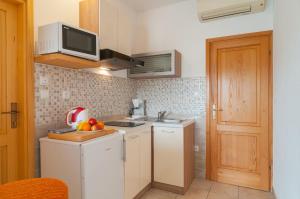 una piccola cucina con lavandino e forno a microonde di Apartments Molo Mare a Hvar