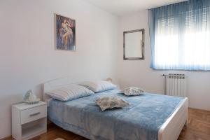 1 dormitorio con 1 cama con manta azul y ventana en Apartment Marija, en Zadar