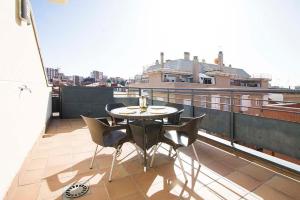 a balcony with a table and chairs on a roof at Apartamentos Naitly Madrid Cuatro Torres in Madrid