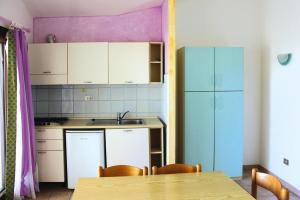 uma cozinha com uma mesa e um frigorífico azul em Apartment building Cannigione - ISR01291-SYA em Cannigione