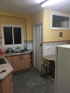 kuchnia ze zlewem i białą lodówką w obiekcie Apartamento de habitaciones privadas en el centro de Málaga w Maladze