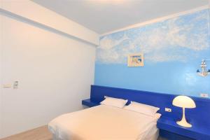 ein blaues Schlafzimmer mit einem Bett und einer blauen Wand in der Unterkunft 哦耶Oh Yeah 包棟民宿 in Luodong