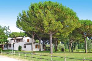 biały dom z płotem i drzewami w obiekcie Holiday resort Azienda Canova Seconda Marina di Grosseto - ITO03010-FYF w mieście Marina di Grosseto