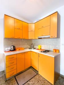 a kitchen with orange cabinets and a sink at Apartment Green Building in Sveti Stefan