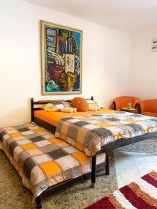 a bed in a room with a painting on the wall at Apartment Green Building in Sveti Stefan