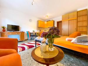 a room with a bed and a vase of flowers on a table at Apartment Green Building in Sveti Stefan