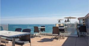 a patio with tables and chairs and the ocean at Hotel Port Marine in Sète
