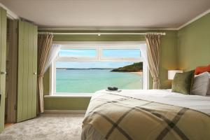 a bedroom with a large window overlooking the ocean at Pedn-Olva in St Ives