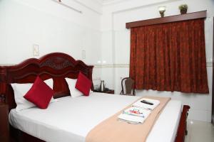 1 dormitorio con cama y cortina roja en Grand View Residency Chennai en Chennai