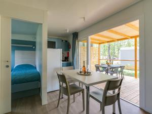 烏馬格的住宿－Adriamar Mobile Homes in Camping Park Umag，厨房以及带桌椅的用餐室。