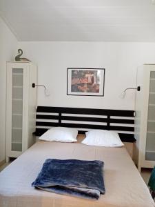 una camera da letto con un letto con una coperta blu sopra di La girolle a Hourtin