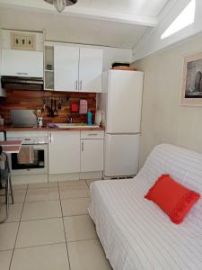 una piccola cucina con letto e frigorifero bianco di La girolle a Hourtin