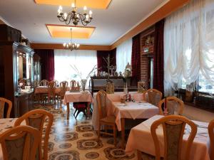 un ristorante con tavoli, sedie e un lampadario di Hotel König Stefan a Deutsch Altenburg
