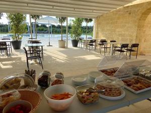 uma mesa com comida com mesas e cadeiras em PODERE CARAFA em Nardò