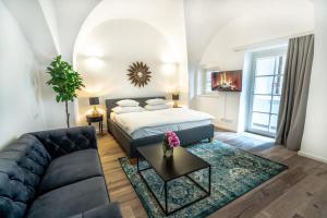 a living room with a bed and a couch at Smile Apartments zum Goldenen Hirschen in Krems an der Donau