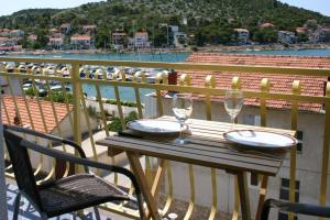 una mesa con 2 copas de vino en el balcón en Villa Stegic, en Tisno