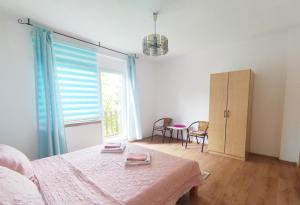 a bedroom with a bed and a large window at Guesthouse D&D in Ličko Petrovo Selo