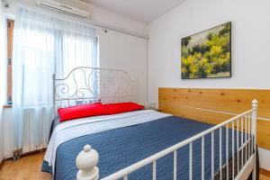 a bedroom with a bed with red pillows at Apartments Jolanda in Medulin