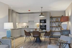a kitchen and living room with a table and chairs at 5* Luxury, City Centre, Brand New Development in Belfast