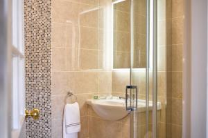 La salle de bains est pourvue d'un lavabo et d'une douche en verre. dans l'établissement The Lansdowne Kenmare, à Kenmare