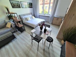 - un salon avec un lit et une table dans l'établissement Apartamenty Rynek, à Białystok
