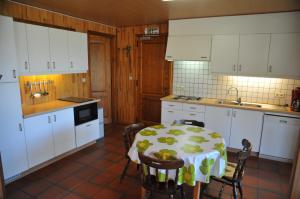 a kitchen with a table and a kitchen with white cabinets at Gite Vivaldi in Durbuy