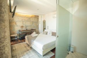 a bedroom with a white bed and a piano at CHARM by YoursPorto in Vila Nova de Gaia
