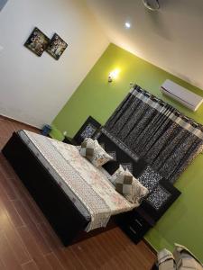 卡拉奇的住宿－Hotel Executive Lodge，一间卧室设有一张床和绿色的墙壁
