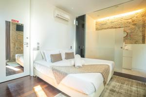 a bedroom with a large white bed with white pillows at CHARM by YoursPorto in Vila Nova de Gaia