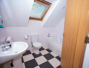 Braeside Guest House, Loch Lomond في دريمن: حمام أبيض مع حوض ومرحاض