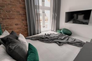 a bed with a blanket on it in a room at HARBOR APARTMENTS - Mariacka in Katowice +48 photos