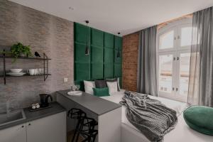 a room with a bed and a desk and a sink at HARBOR APARTMENTS - Mariacka in Katowice