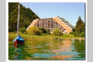 two boats in the water in front of a large building at Seewohnung Ossiachersee atemberaubendes Panorama in Villach
