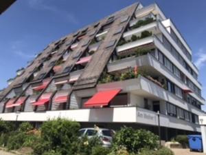 ein großes Apartmenthaus mit Pflanzen auf den Balkonen in der Unterkunft Ferienwohnung am Weiher in Meersburg