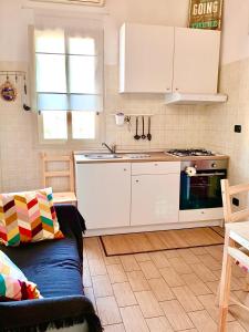 アニョーネ・バーニにあるVilla Violaの白いキャビネットとソファ付きのキッチンが備わります。