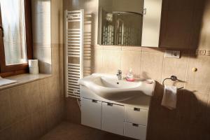 y baño con lavabo blanco y espejo. en Muflon Apartman Jakuzzis Vendégház Mány, en Mány