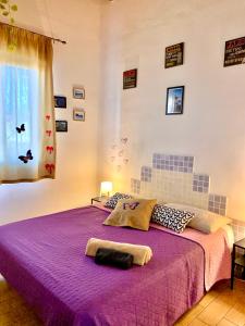 - une chambre avec un lit violet et une fenêtre dans l'établissement Villa Viola, à Agnone Bagni