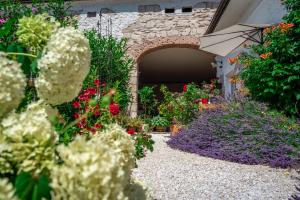 un jardín con flores y un arco de piedra en Haus Diogenes, en Mörbisch am See