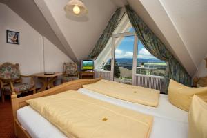 a bedroom with two beds and a large window at JUFA Hotel Schwarzwald in Lenzkirch