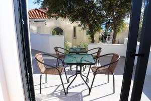 a table and four chairs on a patio with a window at Eagles Apartments & Suites in Ulcinj