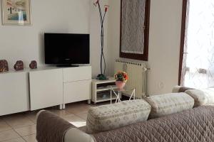 een woonkamer met een bank en een flatscreen-tv bij Feel at Home - CASA LOREDANA in Lovere