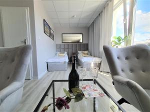 Cette chambre comprend 2 lits et une bouteille de vin sur une table en verre. dans l'établissement Apartamenty Rynek, à Białystok